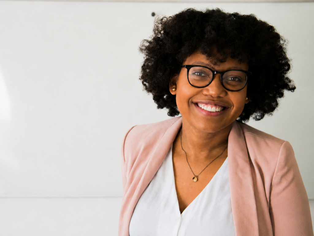 Professional woman smiling confidently in front of a whiteboard