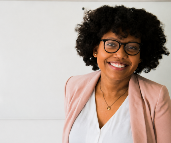 Professional woman smiling confidently in front of a whiteboard