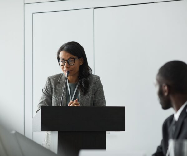 Professional woman speaking at a conference lectern